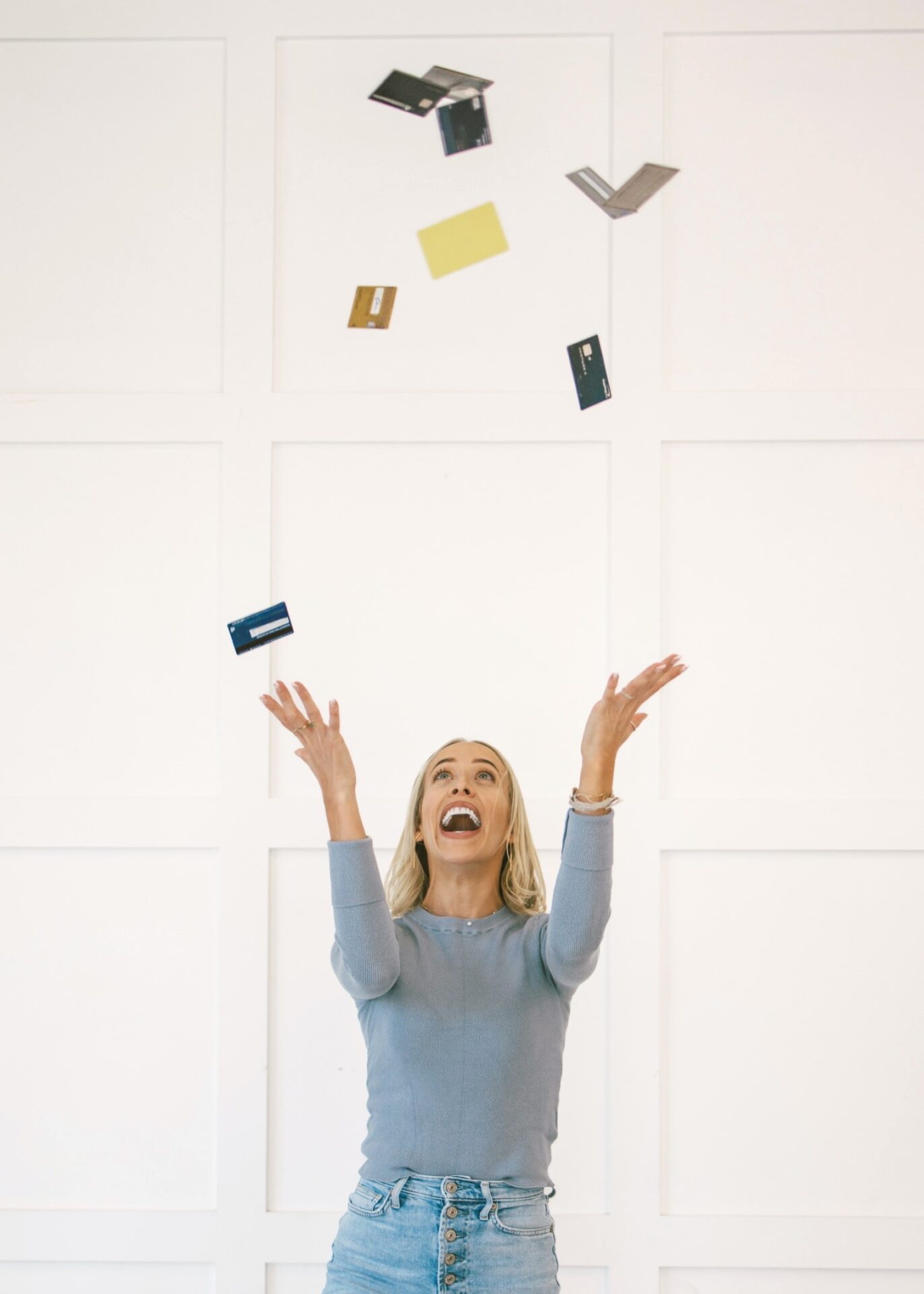 Kam throwing multiple travel credit cards in air celebrating rewards and points